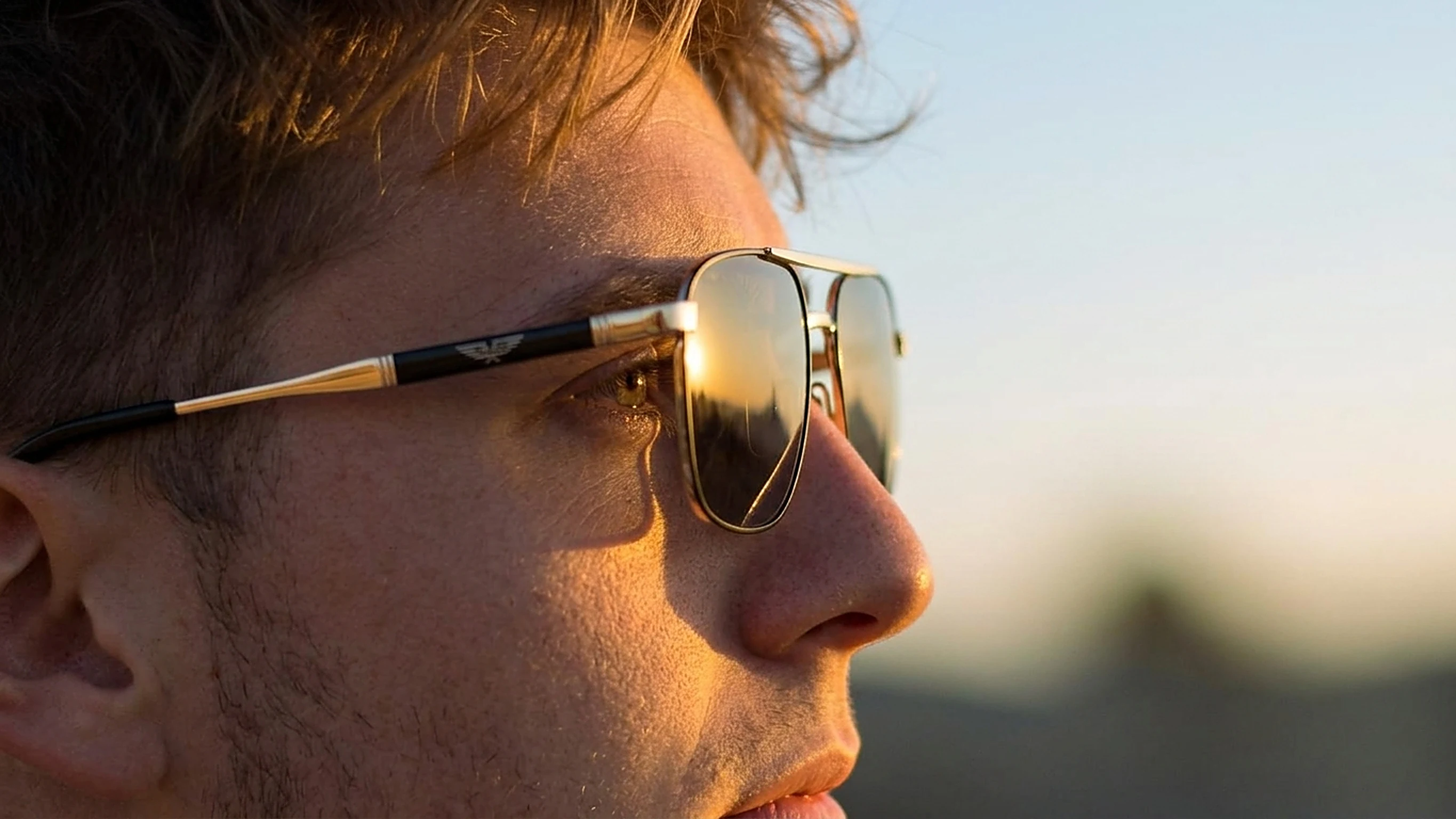 Uomo con occhiali da sole Police navigator dorati al tramonto — Stylottica Ceglie